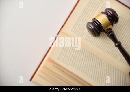Hintergrunddetails mit Hammer auf offenem Gesetzbuch isoliert auf weißem Tisch. Draufsicht Stockfoto