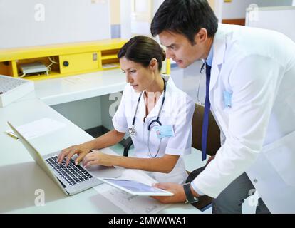 Bestätigt, was sie vermutet haben. Ein medizinisches Team, das online recherchiert. Stockfoto