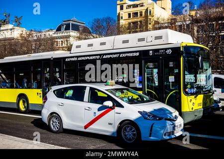 Eine gelbe Flughafenraste und ein weißes Taxi warten an der Ampel direkt vor dem Bahnhof Atocha, Madrid Spanien Stockfoto