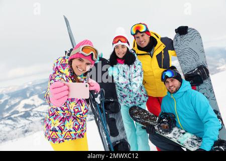 Eine Gruppe von Freunden macht Selfie in den schneebedeckten Bergen. Winterurlaub Stockfoto