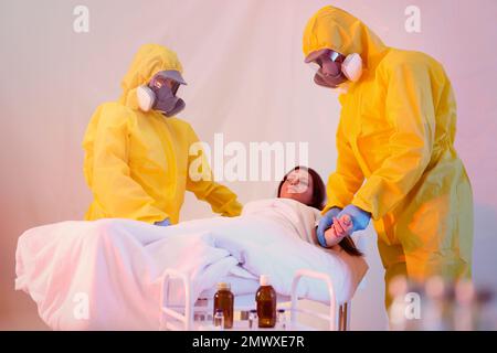 Professionelle Sanitäter untersuchen Patienten mit Virus in der Quarantänestation Stockfoto