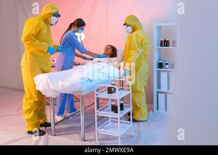 Professionelle Sanitäter untersuchen Patienten mit Virus in der Quarantänestation Stockfoto