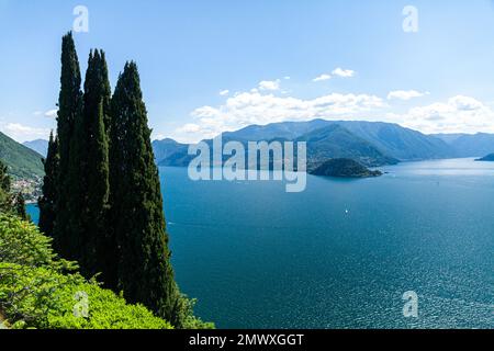 Panoramablick aus der Vogelperspektive auf den Comer See von Varenna in Richtung Bellagio im Zentrum des Sees mit klarem blauen Himmel im Sommer, Boote auf dem Wasser Stockfoto