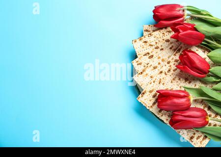 Matzen und Blumen auf hellblauem Hintergrund, flach liegend mit Platz für Text. Passover (Pesach) Seder Stockfoto