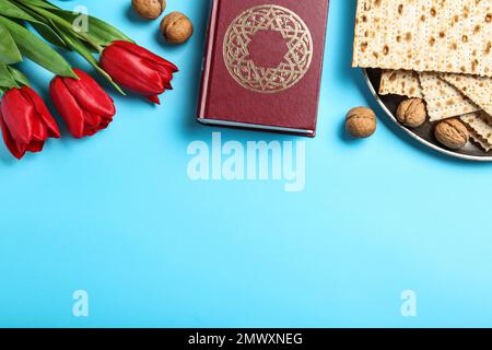 Flache Lay-Komposition mit Matzen auf hellblauem Hintergrund, Platz für Text. Pessach-Feier Stockfoto