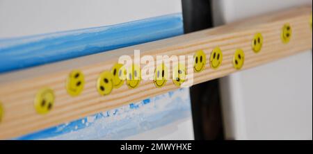 Smiley-Aufkleber auf einem hölzernen Bücherregal, Kinderzimmer, Happy-Sticker Stockfoto