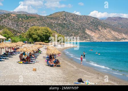 Touristen ruhen sich am Kieselstrand von Chalikia in Paleochora aus. Kreta, Griechenland Stockfoto