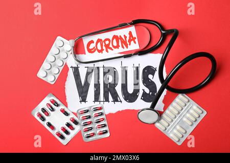 Flache Laienzusammensetzung mit Phrase CORONA-VIRUS und Medikamenten auf rotem Hintergrund Stockfoto
