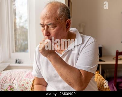 Ein älterer Mann hustet. Leiden der Symptome der Winterkälte und Grippe. Stockfoto