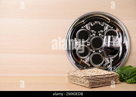 Symbolische Pesach-Elemente (Passover Seder) auf Holztisch, Platz für Text Stockfoto