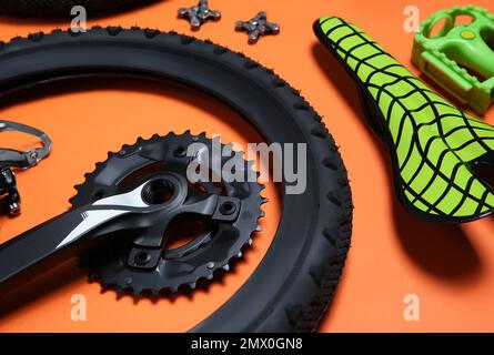 Satz verschiedener Fahrradteile auf orangefarbenem Hintergrund, Nahaufnahme Stockfoto