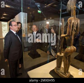 France's President Francois Hollande, looks at a a woman statue using a pestle and a mortar, Dogon N'duleri style, Mali of the 17th-18th century as he attends the opening of the exhibition 'Eclectic' at the Quai Branly museum in Paris, Tuesday, Nov. 22, 2016. The exhibition runs from November 23 to April 2, 2017. (AP Photo/Michel Euler, Pool)