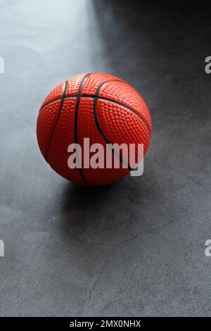 Kleiner Basketball aus weichem Schaumstoff auf dunklem Hintergrund Stockfoto