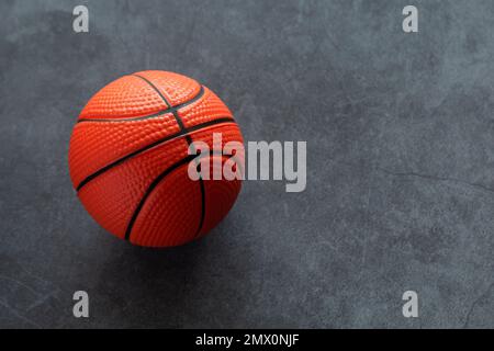 Kleiner Basketball aus weichem Schaumstoff auf dunklem Hintergrund Stockfoto