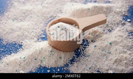 Von oben weißes Waschpulver für die tägliche Hygiene in einem hölzernen Messbecher, der im hellen Raum auf dem Tisch platziert wird Stockfoto