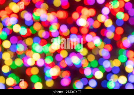 Abstrakte Regenbogenfarben verschwommene Lichtkreise mit Bokeh-Effekt auf dunklem Hintergrund mit roten Schatten Stockfoto