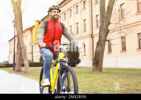 Kurier mit Thermotasche, Fahrrad im Freien. Lebensmittellieferservice Stockfoto