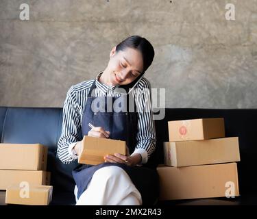 Start Small Business KMU, Unternehmer Eigentümer mit Smartphone oder Tablet erhalten und prüfen online kaufen Shopping um Vorbereitung Pack Stockfoto