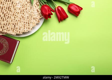 Matzen, Tora und Blumen auf grünem Hintergrund, flach liegend mit Platz für Text. Passover (Pesach) Seder Stockfoto