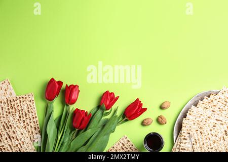 Flache Lay-Komposition mit Matzen auf grünem Hintergrund, Platz für Text. Pessach-Feier Stockfoto