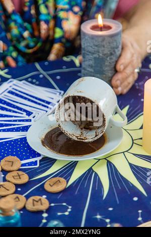 Ein Wahrsager liest Vermögen auf Kaffeesatz. Selektiver Fokus. Frau. Stockfoto