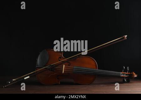 Klassische Geige und Schleife auf Holzhintergrund Stockfoto