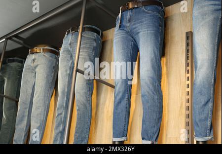 Verschiedene stilvolle Jeans auf Schaufensterpuppen im Geschäft Stockfoto