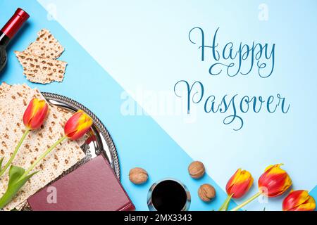 Flache Laienzusammensetzung mit symbolischen Pesach-Elementen (Passover Seder) auf blauem Hintergrund, Stockfoto