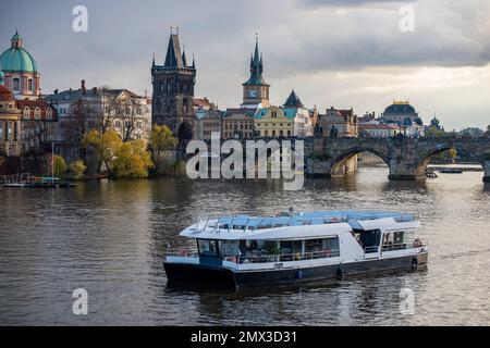 Panoramablick auf den wunderschönen antiken Turm, das Gebäude, die Kirche und einen Teil der Karlsbrücke, die Moldau mit dem Boot. Tschechische republik, Prag. Stockfoto