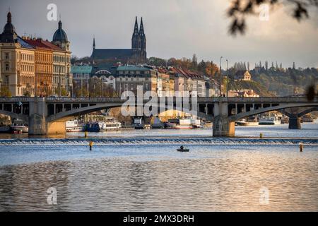 Panorama des historischen Teils vom Fluss, Vysehrad Kirche, altes Gebäude und Jiraskuv Brücke, Boot, Fischer auf dem Fluss, schöner Herbstuntergang. Prag, Tschechisch Stockfoto