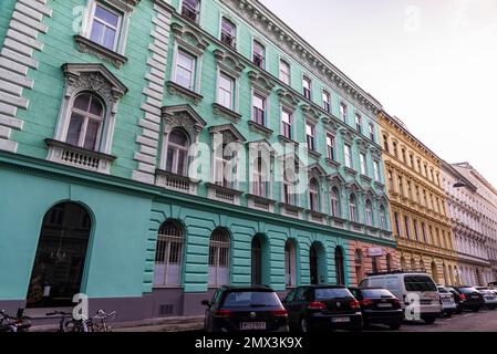Wien, Österreich - 16. Oktober 2022: Klassische Gebäude mit grünen, gelben und rosafarbenen Fassaden in Wien, Österreich Stockfoto