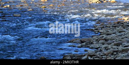 Wasserbrecher auf der Oberfläche des Flusses zwischen felsigen Ufern Stockfoto
