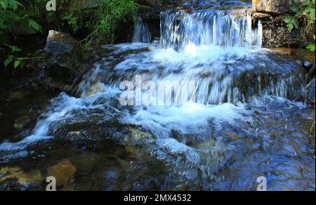 Der Wasserfluss in einem kleinen Wasserfall in einem Bergbach Stockfoto