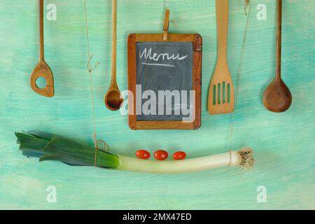 Menüvorlage mit Tafel, Lauch, Tomaten und Holzlöffeln, kostenloser Kopierbereich Stockfoto