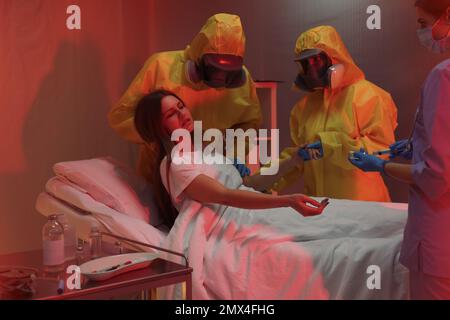 Professionelle Sanitäter untersuchen Patienten mit Virus in der Quarantänestation Stockfoto
