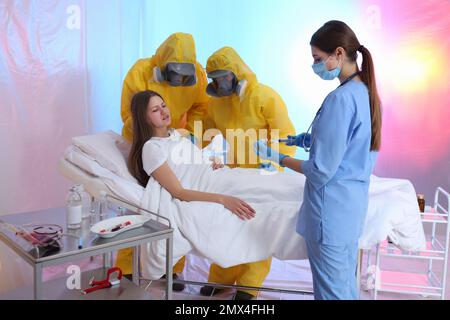 Professionelle Sanitäter untersuchen Patienten mit Virus in der Quarantänestation Stockfoto