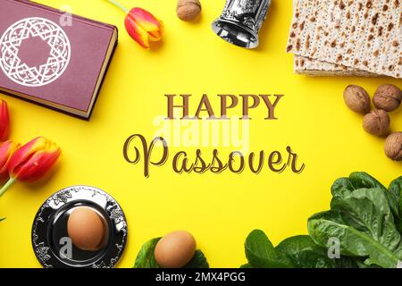 Flache Laienzusammensetzung mit symbolischen Pesach-Elementen (Passover Seder) auf gelbem Hintergrund Stockfoto