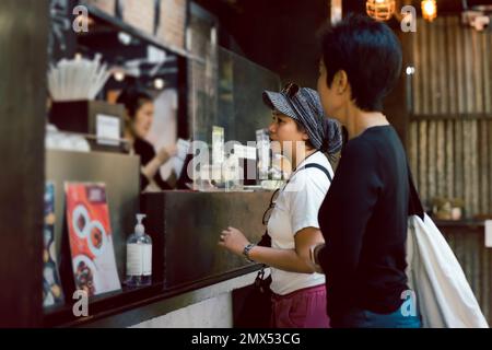 Zwei Freundinnen, die eine Bestellung aufgeben, um in einem Café zu essen. Stockfoto