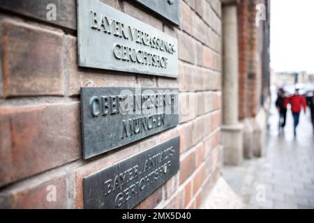 München, Deutschland. 02. Februar 2023. Die Schrift „Bayer. Verfassungsgerichtshof", "Oberlandesgericht München" und "Bayer". Jurygericht' ist auf den Schildern am Eingang des Gerichtsgebäudes vom Obersten Landesgericht zu sehen. Das Oberlandesgericht befasst sich mit der Verwendung des Begriffs „Neuschwanstein“ für ein Hotelgeschäft. Kredit: Matthias Balk/dpa/Alamy Live News Stockfoto