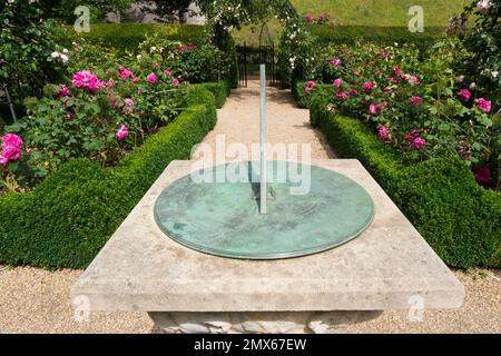 Die Sonnenuhr ist umgeben von den wunderschönen altmodischen Rosen Mme Isaac Péreiré, Prinzessin Anne und Gertrude Jekyll in der formellen Schachtel in der Mitte Stockfoto