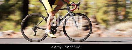 Professioneller männlicher Radfahrer in Rennkleidung während einer Radtour im Freien. Verwendetes Schwenkverfahren Stockfoto