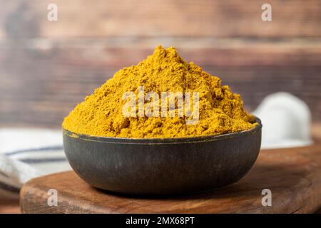 Curry Masalapulver. Kurkumapulver oder Currypulver Gewürz in einer Schüssel auf Holzhintergrund. İndian Gewürze. Trockengewürz-Konzept. Schließen Stockfoto