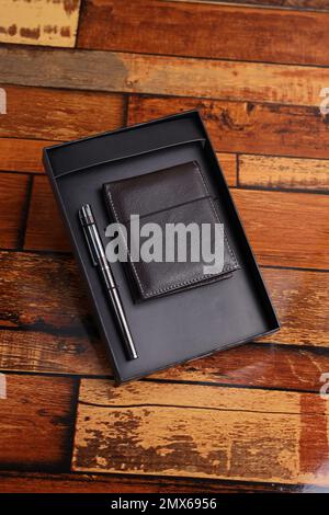 Geschenkbox für Unternehmen, Geldbörse und Stahlstift, Blick von oben auf den Holztisch Stockfoto