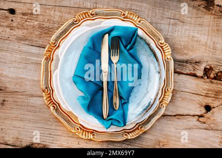 Goldene und blaue elegante Tischsets auf Holzhintergrund Stockfoto