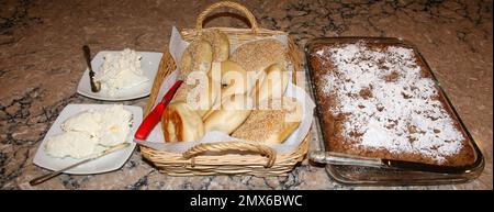 Bagels und Kaffeebeutel für Brunch auf einer Küchentheke mit Frischkäse und Butter. Stockfoto