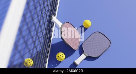 Schläger und Bälle zum Spielen von Pickleball im Sportnetz auf dem Platz. 3D-Rendering Stockfoto