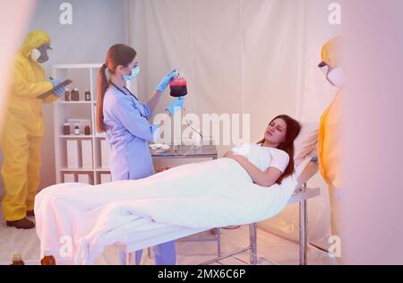 Professionelle Sanitäter untersuchen Patienten mit Virus in der Quarantänestation Stockfoto