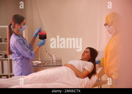 Professionelle Sanitäter untersuchen Patienten mit Virus in der Quarantänestation Stockfoto