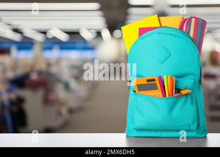 Heller Rucksack mit Schulpapier auf dem Tisch im Einkaufszentrum. Platz für Text Stockfoto