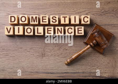 Wooden cubes with words DOMESTIC VIOLENCE and gavel on table, flat lay Stockfoto